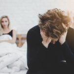 man stressed in relationship. angry woman in bed